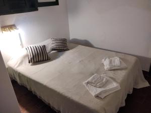 Una cama con dos toallas encima. en GREEN HOME en Córdoba
