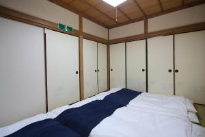 un letto in una camera con armadi bianchi di Tokai Ryokan Ichigokan - Vacation STAY 29187v ad Atami