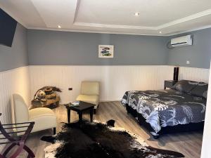 a bedroom with a bed and a chair and a table at Inaki Uhi Hotel in Hanga Roa