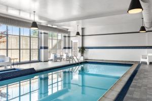 a swimming pool with blue water in a building at Delta Hotels by Marriott Midwest City at the Reed Conference Center in Del City