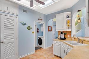 a kitchen with a sink and a washing machine at LaJuana Iguana - House in Port Aransas