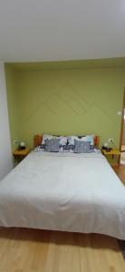 duże białe łóżko w pokoju z zieloną ścianą w obiekcie KovacInalux Apartmani w mieście Pale