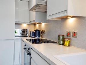 a kitchen with white cabinets and a counter top at Harbour View in Johnshaven