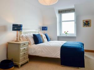 een slaapkamer met een bed en een lamp op een nachtkastje bij Harbour View in Johnshaven