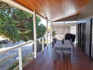 a wooden deck with a table on a porch at Normanville Getaway in Normanville