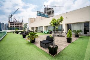 a rooftop patio with plants and a building at Elite 47 Interlomas in Mexico City