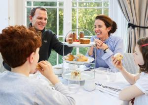 a family sitting around a table eating dessert at The Ickworth Hotel And Apartments - A Luxury Family Hotel in Bury Saint Edmunds