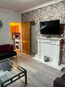 ein Wohnzimmer mit einem Kamin und einem Flachbild-TV in der Unterkunft Ovington Grove 2 fully equipped kitchen free parking 3 bedrooms Netflix in Newcastle upon Tyne