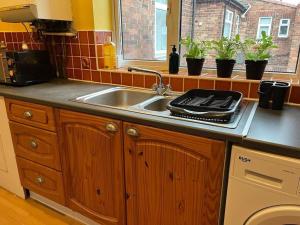a kitchen counter with a sink and a window at Ovington Grove 2 fully equipped kitchen free parking 3 bedrooms Netflix in Newcastle upon Tyne