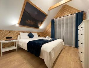 una camera con un grande letto e una finestra di Domki przy skwerku a Zakopane