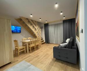 ein Wohnzimmer mit einem Sofa und einem Esstisch in der Unterkunft Domki przy skwerku in Zakopane