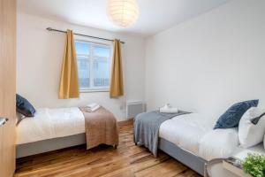 a bedroom with two beds and a window at 2 bedroom flat near London ExCel in London