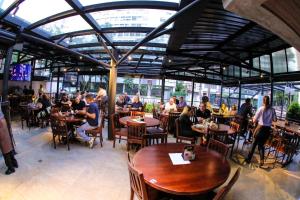 un grupo de personas sentadas en mesas en un restaurante en Flat 1092 Jardins, en São Paulo