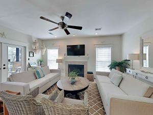 a living room with a couch and a ceiling fan at Aloha Sandy Bay in Blue Mountain Beach