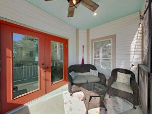 a porch with wicker chairs and a glass table at Aloha Sandy Bay in Blue Mountain Beach