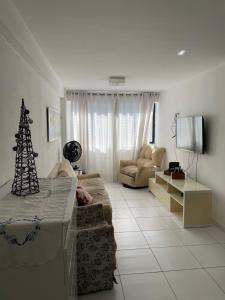 a living room with a christmas tree and a couch at Apartamento Pajuçara in Maceió