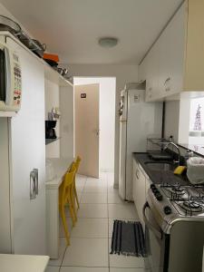 a kitchen with a stove and a counter top at Apartamento Pajuçara in Maceió