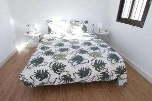 Disfruta junto al mar في لا لاغونا: غرفة نوم مع سرير لحاف أخضر و أبيض
