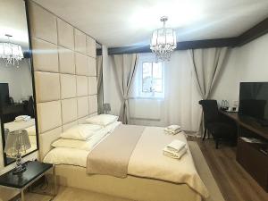 a bedroom with a bed and a desk and a television at Apartamenty "Starówka" in Kazimierz Dolny