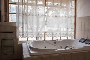 a bath tub in a bathroom with a window at La Quinta San Miguel-Located Between Two Volcanoes in Cotacachi