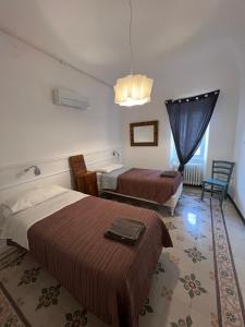a hotel room with two beds and a window at Casa del Poeta in Riva Ligure