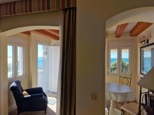 una sala de estar con una silla azul y ventanas en Sherry Playa, en El Puerto de Santa María