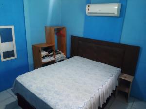 1 dormitorio con 1 cama en una habitación azul en Cantinho da Jô, en Barra Grande