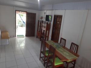 comedor con mesa y sillas y cocina en Cantinho da Jô, en Barra Grande