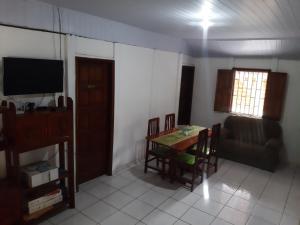 sala de estar con mesa, sofá y TV en Cantinho da Jô, en Barra Grande