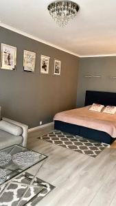 - une chambre avec un lit, un canapé et un lustre dans l'établissement Platinum Apartment przy plaży, z parkingiem, z dużym balkonem, à Sopot