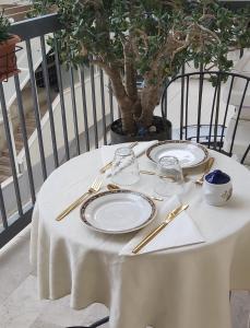 a white table with plates and glasses on it at Tilde B&B in Cefalù