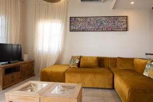 een woonkamer met een bank en een tv bij Curacao Luxury Holiday Rentals in Willemstad