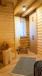 a room with a bed and a chair in a log cabin at Chałupy w Lesie Skawinki in Skawinki