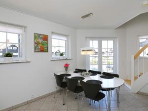 ボーゲンセにある6 person holiday home in Bogenseの白いダイニングルーム(白いテーブルと椅子付)