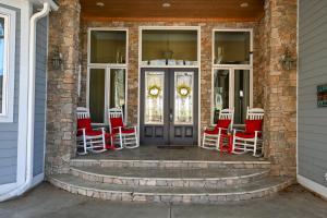 een veranda met rode en witte stoelen en een deur bij Cardinal Rose Lakehouse in Martin
