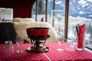 einen Tisch mit Weingläsern und eine Schüssel auf dem Tisch in der Unterkunft Chalet-Hotel Beau-Site in Adelboden