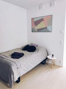 a white bedroom with a bed and a table at New Studio Mint near Airport in Vantaa
