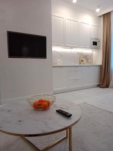 una cocina con una mesa con un tazón de naranjas. en Apartament Glamour Chełm en Chełm