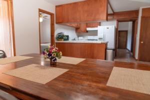 a kitchen with a wooden table with a vase of flowers on it at Riviera Motor Lodge in Saratoga