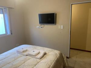 1 dormitorio con 1 cama y TV en la pared en Departamento Céntrico en Goya