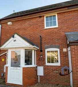 a brick house with a white door and windows at Franklin House 2 bed, king bed, parkingx2, workspace, wi-fi, corporates in Hardingstone