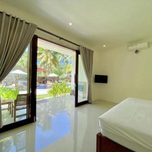 a bedroom with a bed and a view of a pool at The Kebon Lombok in Kuta Lombok