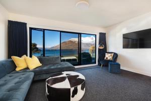 a living room with a couch and a large window at TAHUNA LAKEFRONT LUXURY, Central Location in Queenstown