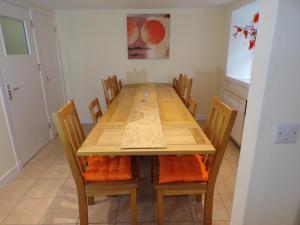 een eetkamer met een houten tafel en stoelen bij Whinstone Holiday Home in Falkland in Falkland