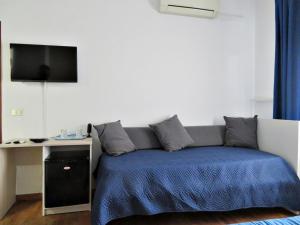 a bedroom with a bed and a desk with a television at La Feluca Rooms & Breakfast in Messina