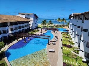 an aerial view of a resort with a swimming pool at Maui Beach Residence, 3 quartos, Tamandaré PE in Tamandaré