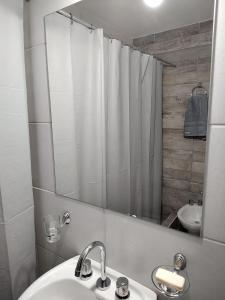 y baño con lavabo y ducha con espejo. en CABAÑA PEÑA D' BACO en San Rafael