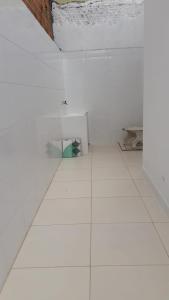 um quarto com paredes brancas e piso em azulejo branco em Casa Adequadra para Home-Office. em Caruaru