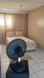 uma ventoinha numa mesa num quarto com uma cama em Casa Adequadra para Home-Office. em Caruaru