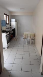 uma cozinha com piso em azulejo branco, uma mesa e cadeiras em Casa Adequadra para Home-Office. em Caruaru